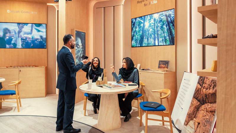 Three delegates share an animated conversation at the Royal Commission for AlUla hospitality space during the World Economic Forum in Davos, Switzerland.
