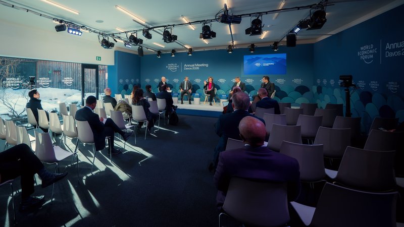 Attendees listen to a panel in a sunlit Annual Meeting 2026 venue during the World Economic Forum in Davos, Switzerland.
