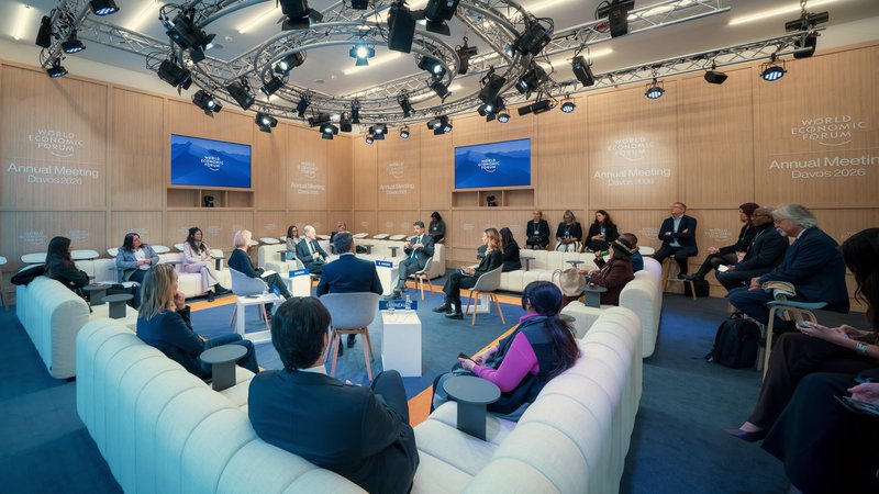Participants gather in a circular lounge for a focused leadership discussion beneath a dramatic lighting rig during the World Economic Forum in Davos, Switzerland.